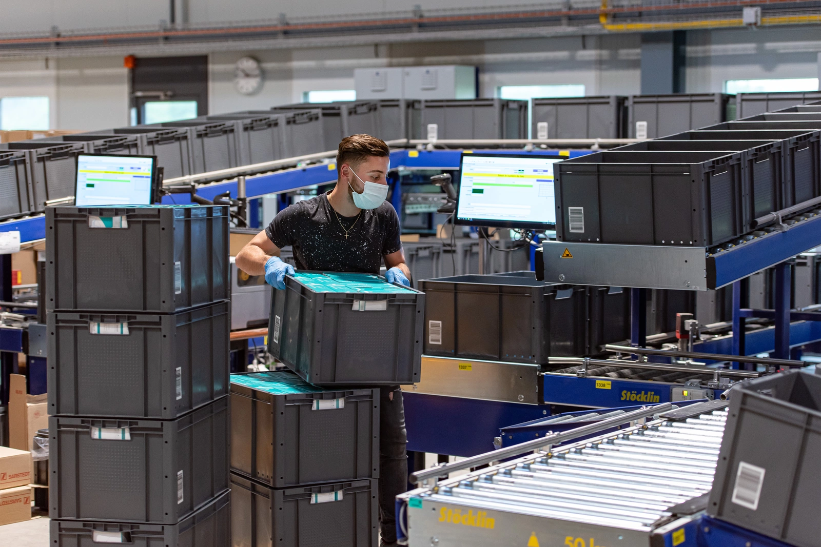 Photo d'un jeune homme qui déplacent des caisses noires