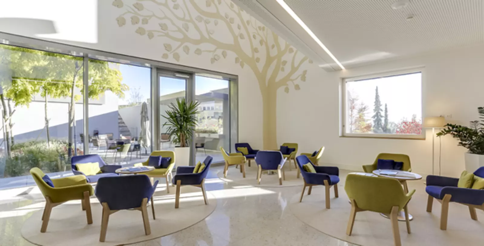Photo du hall de l'Hôtel des Patients avec des tables et des chaises